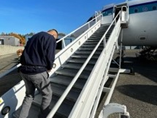 Nicaraguan national walking up stairs to plane